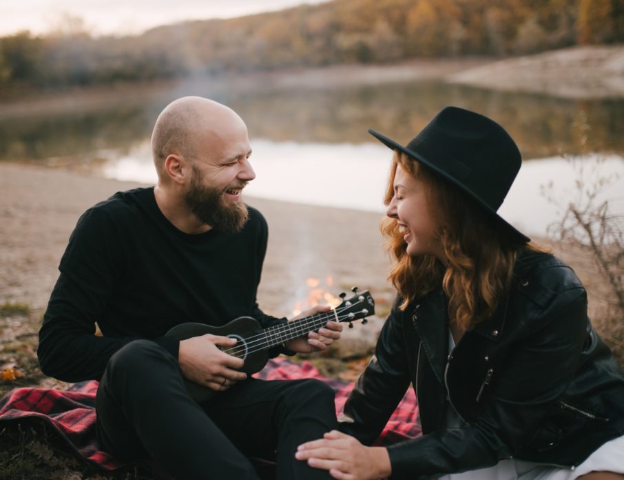couple laughing and singing with guitar