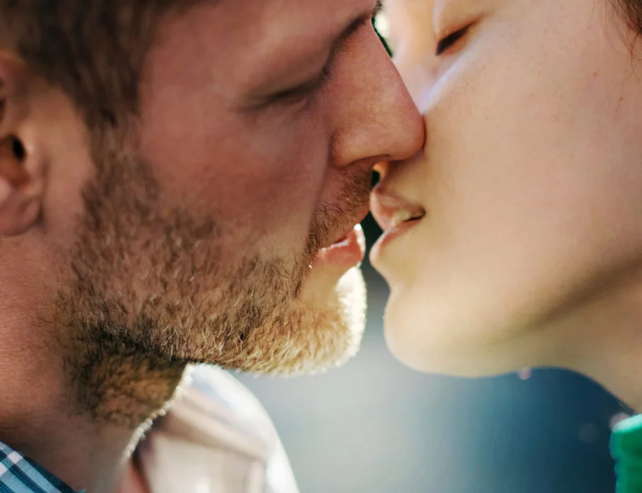 Close-up image of romantic couple leaning in for a kiss while figuring out the difference between infatuation vs. love.