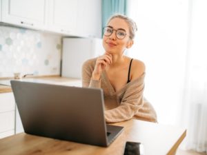 attractive young woman in front of laptop using a tinder profile template