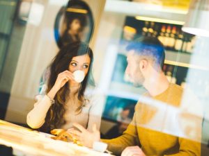 Attractive couple in a cafe coming up with things to talk about on a first date