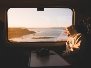 Men staring out train window thinking about should we break up or not