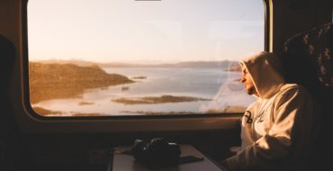 Men staring out train window thinking about should we break up or not