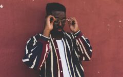 Attractive young man standing in front of red wall and wearing a cool first date outfit for men