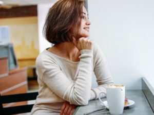 Attractive 40 year old woman drinking coffee in cafe