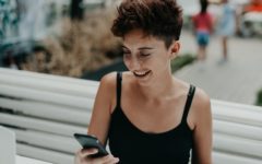 attractive young woman holding phone and laughing using the best tips for online dating