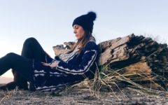 Sad looking woman sitting on the ground, leaning against a rock and thinking about the signs your marriage is over