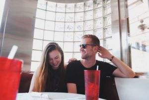 woman practising how to flirt with a guy she likes in a restaurant