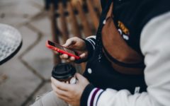 man using mobile phone on a dating app thinking of things to ask a girl