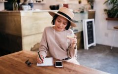 attractive lady sitting at table working out how to use dating profile headlines to attract guys
