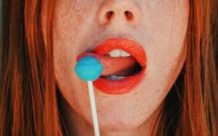 attractive red head woman licking a popsicle as the definition of flirting