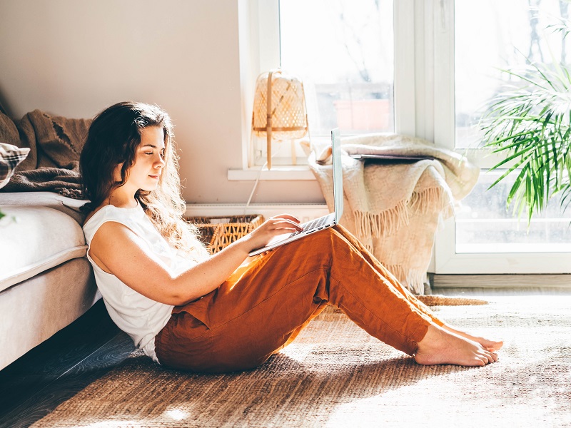 attractive woman on laptop in her bedroom dating herself in self-isolation