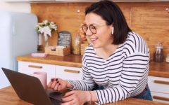 lady standing in kitchen with laptop trying out virtual date ideas