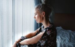 a woman in a bedroom lost in thought about how to break up with someone nicely