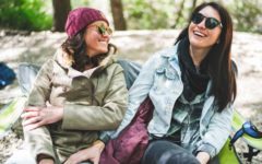 two women who met on one of the best bisexual dating apps sitting outside and laughing