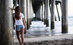 woman standing under a pier thinking about toxic relationship definitions