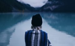 woman sitting alone by a lake considering the characteristics of an unhealthy relationship