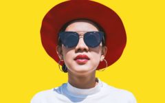 woman with red hat standing in front of yellow wall challenging her limiting beliefs