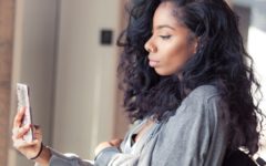 young attractive woman holding mobile phone reading about dating terms