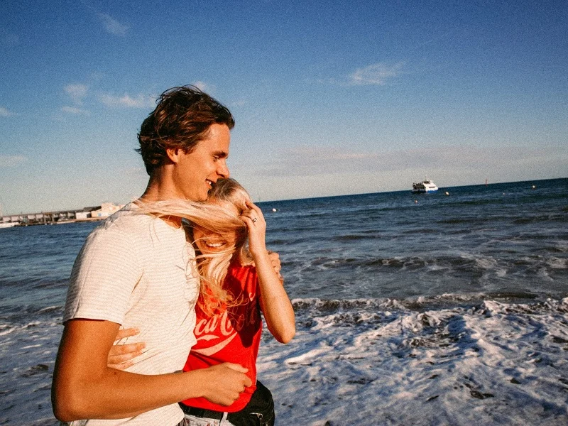 couple laughing at the beach disproving what women think men want