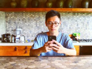 man standing in kitchen on mobile showing how to approach online dating
