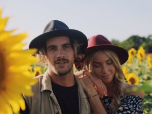 Attractive couple standing in field of sunflowers, happily using healthy relationship rules