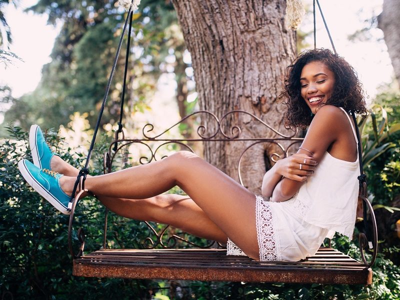 attractive woman sitting on bench in garden thinking about what is self love