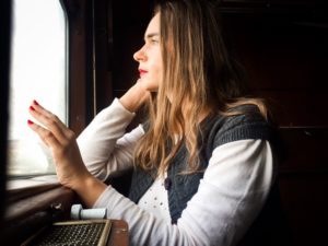 woman looking out window wondering am I still in love or not