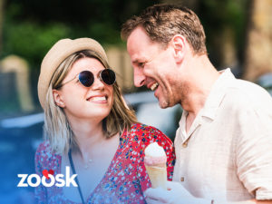 Man and woman laughing while they have ice cream and are Zoosk singles on a date