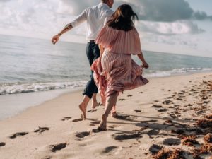 couple running on beach experiencing what does it mean to love someone