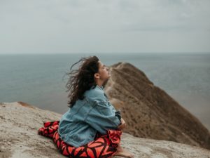 woman sitting on mountain exploring how to get over someone fast