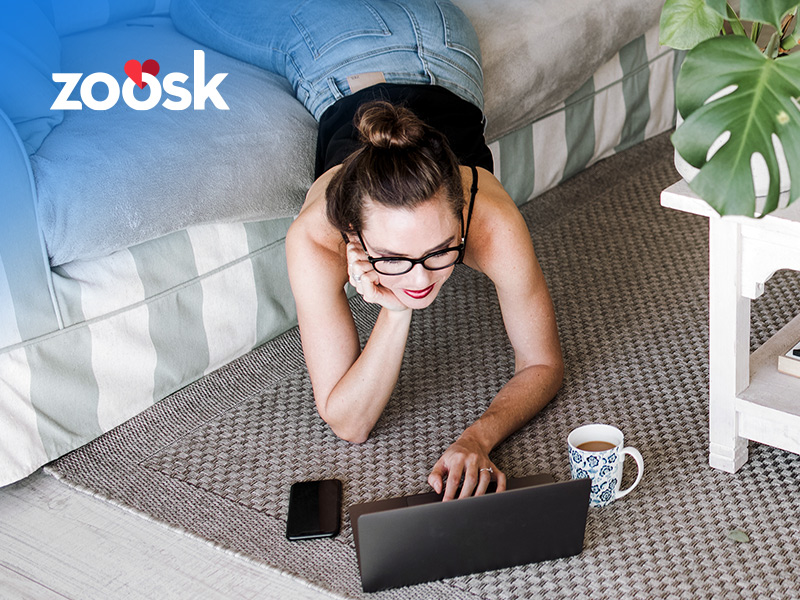woman lying on her sofa using the Zoosk website on her laptop