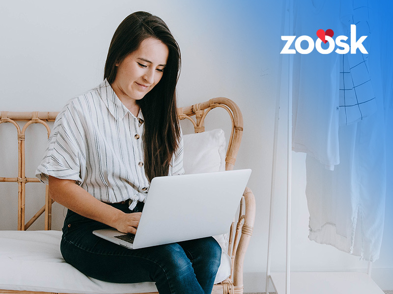 Smiling woman on her laptop using the Zoosk full site
