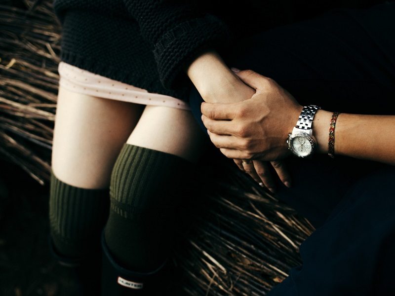 couple in cuffing season relationship hold hands in autumn lighting