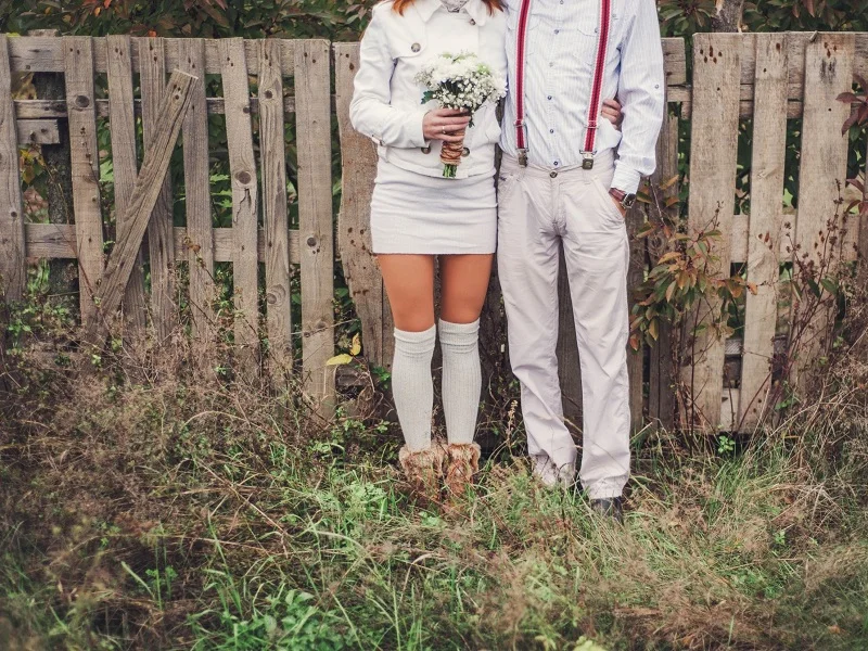 young couple wearing white standing outside ready to get married after the proposing