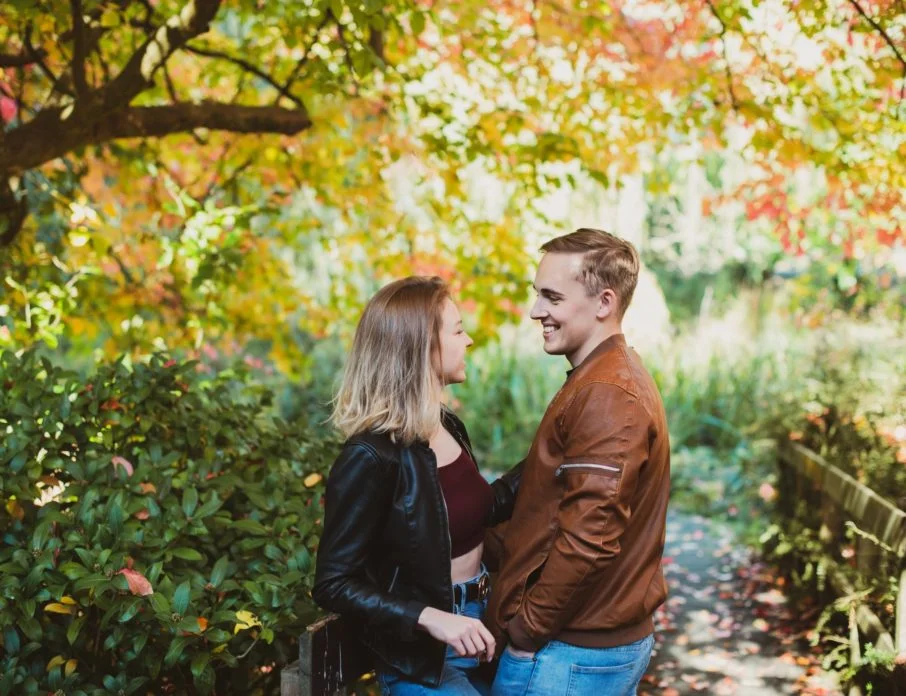 couple laughing while on walk in park in Autumn