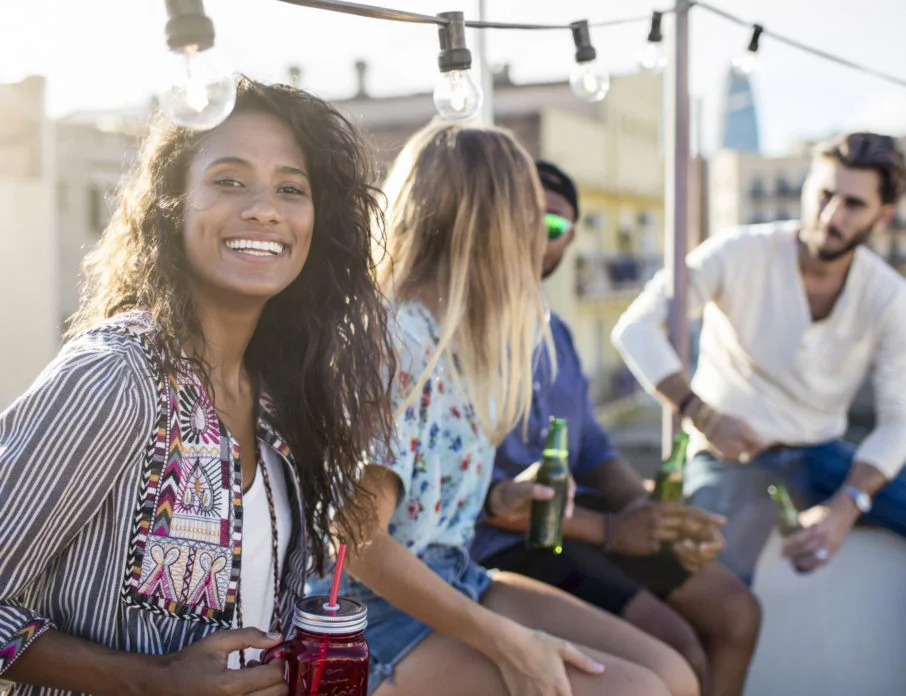 Woman looking towards camera and smiling while enjoying a singles dating event outdoors.