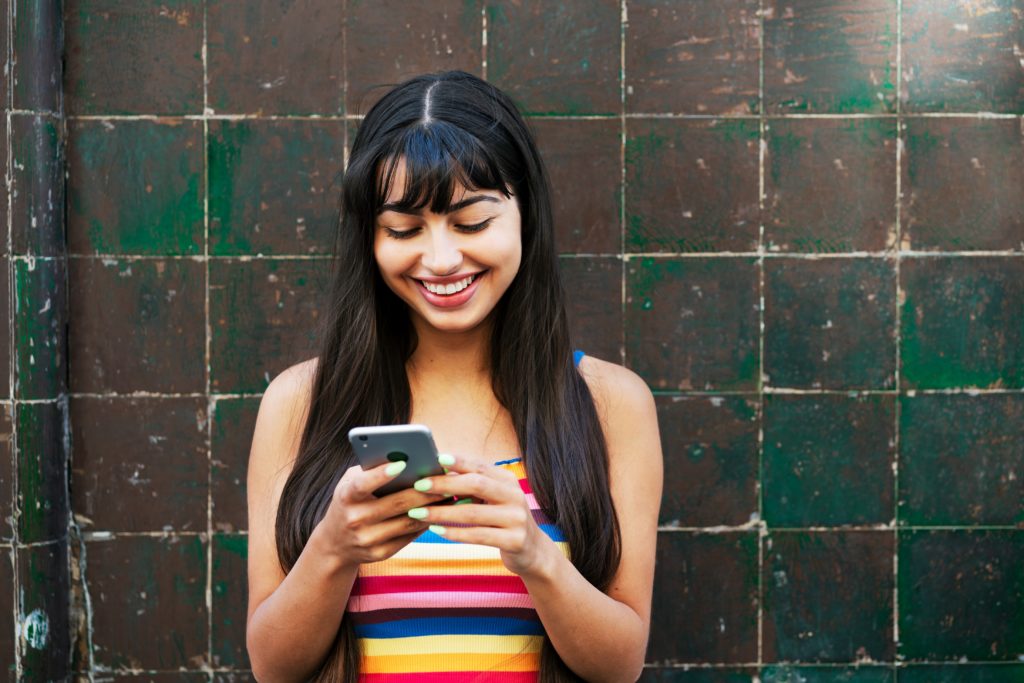Single woman in Phoenix holding her phone using a dating app