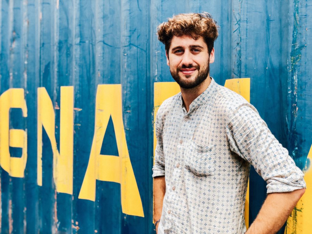 single man standing in front of street mural smiling in Philadelphia
