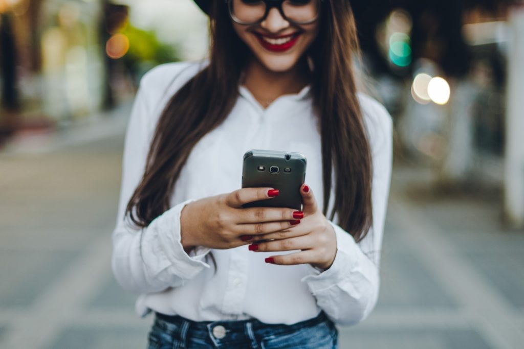 Attractive woman wearing hat and texting on her phone in Nashville