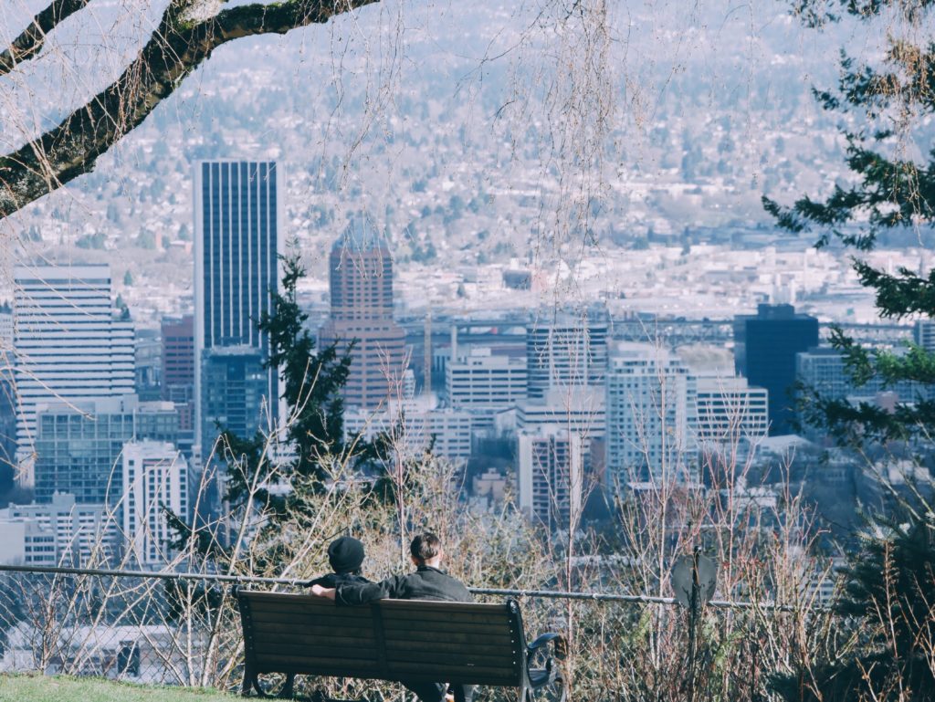 couple sitting on bench overlooking Portland