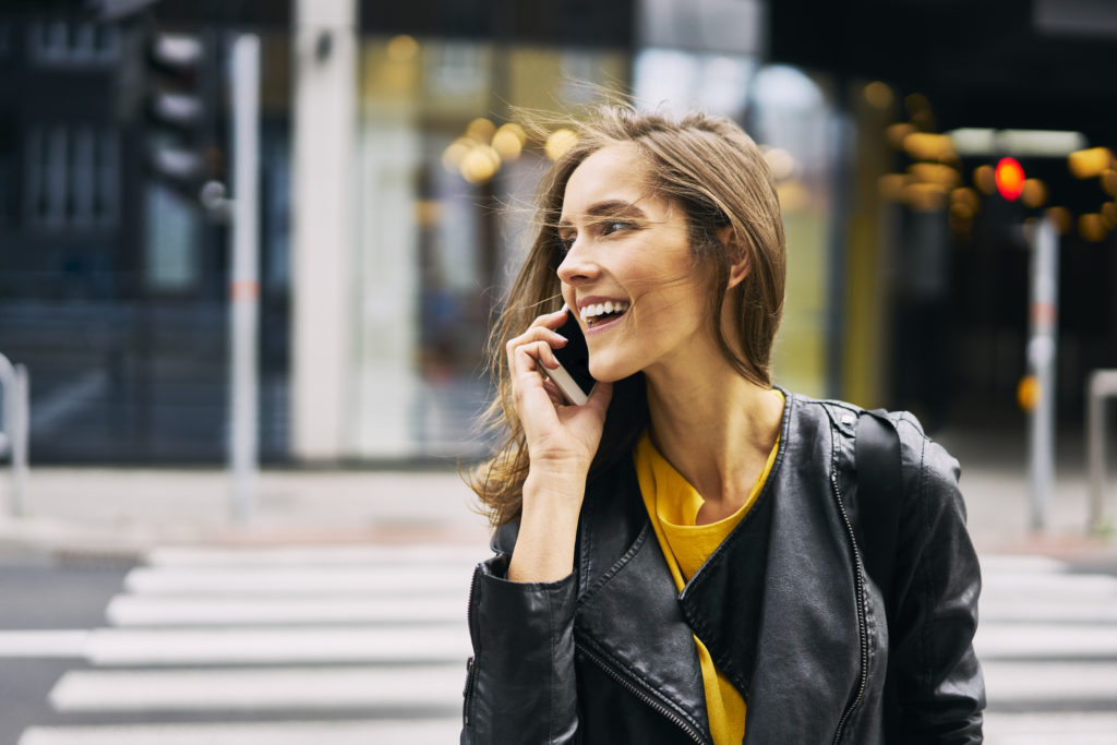 Happy woman laughing and smiling on the phone while dating in Indianapolis.