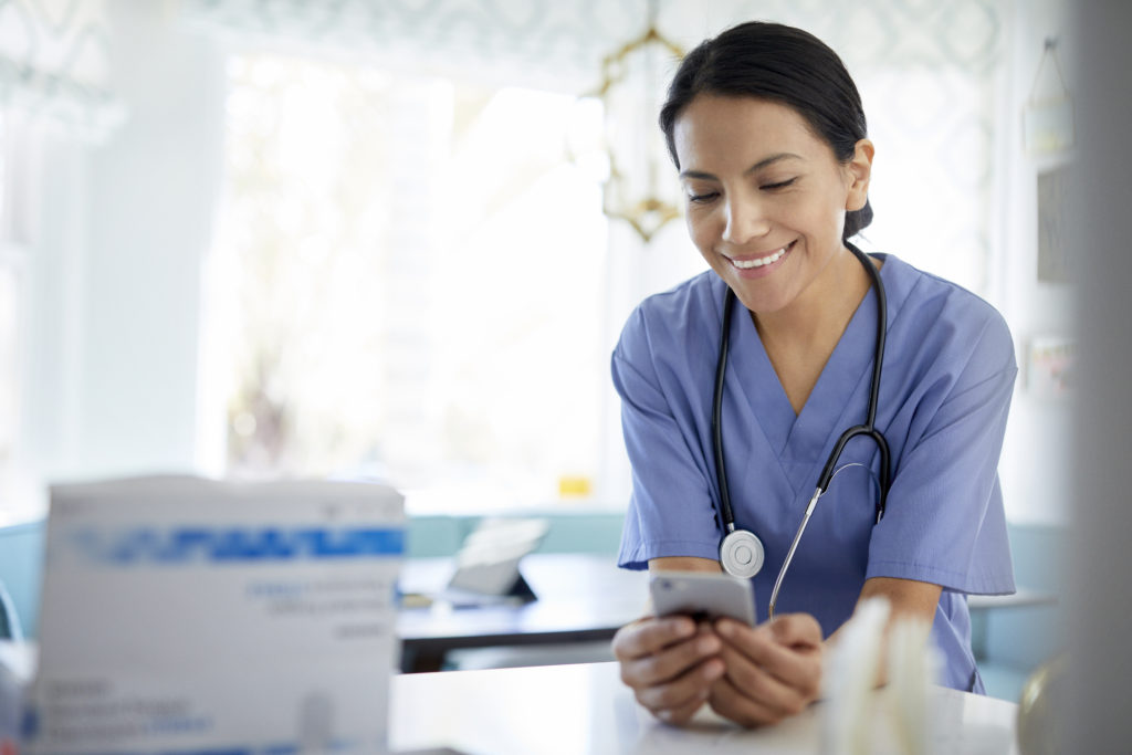 Female doctor smiling and using mobile phone to meet other single doctors online.