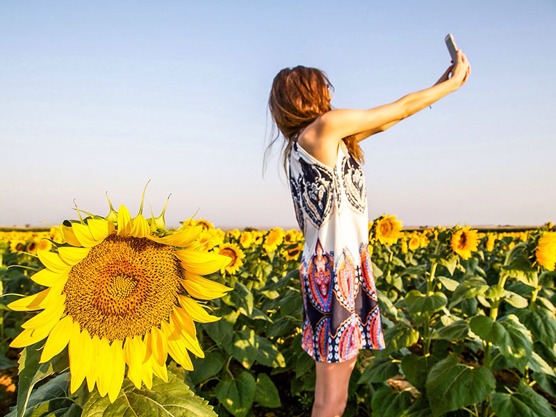 A woman who followed our online dating profile tips who is taking a positive, fun picture.