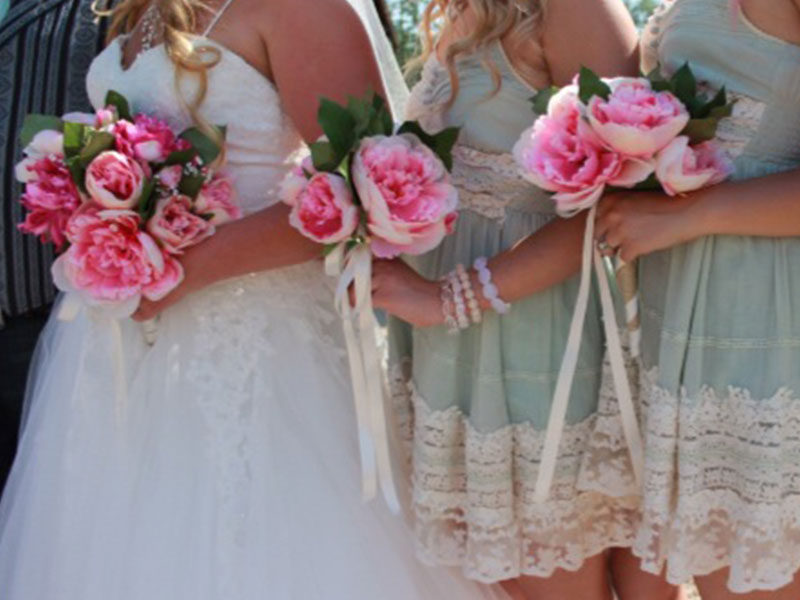 Bridesmaids lined up next to a bride at a wedding.