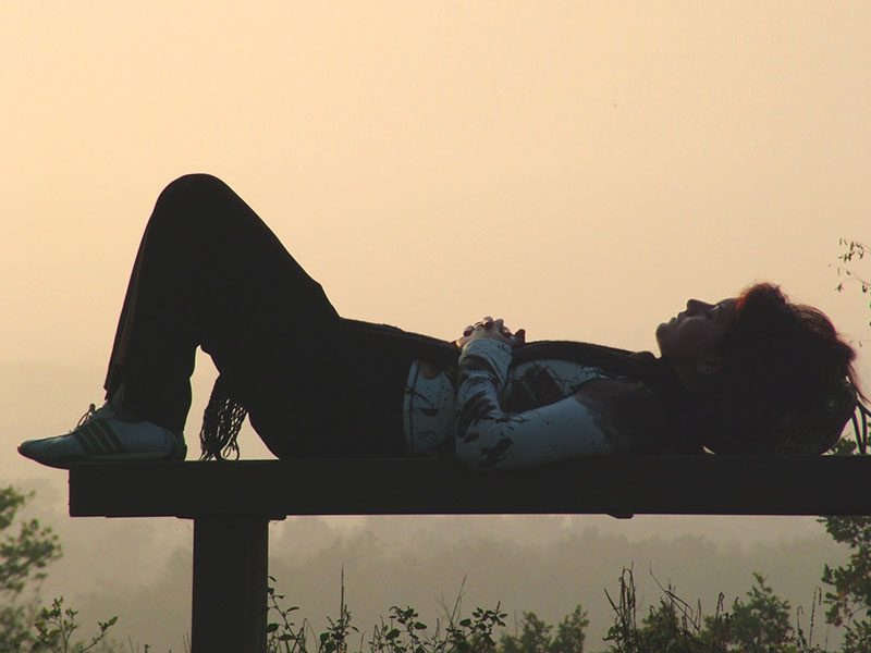 A woman battling depression on a park bench thinking about her relationship problems.