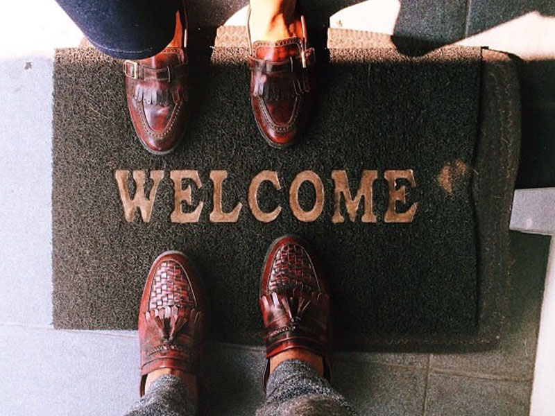 A couple with their feet on the welcome mat, ready to move in together.