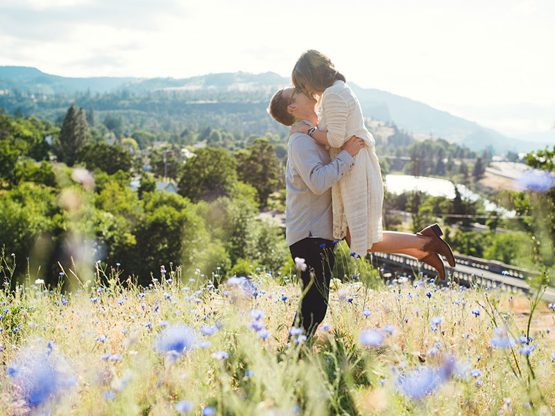 A woman in a field hugging a man.