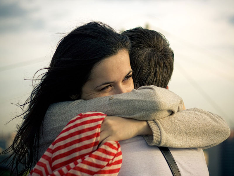 A woman hugging a man.