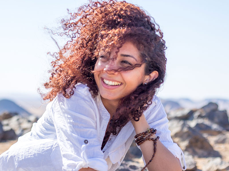 A woman enjoying single life in your 30s by laughing in the wind.