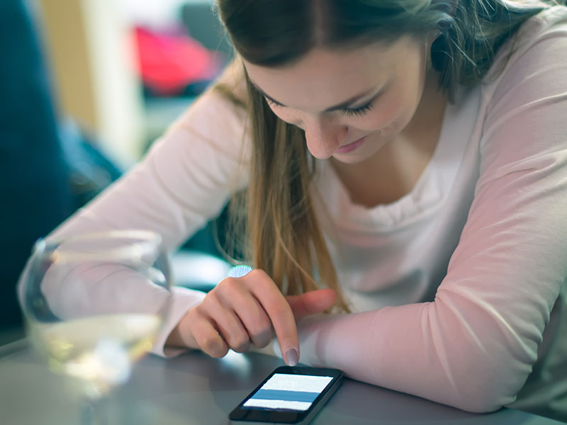 A woman who's online dating on her phone giving online dating tips for men.